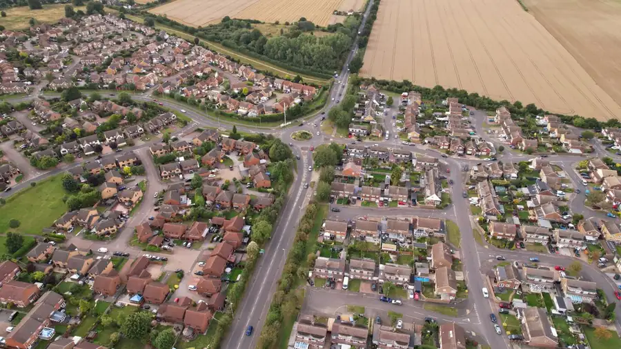 Aerial view of a sprawling English housing estate with rows of low-pitched tiled roofs like those built around Mansfield in the 1970s
