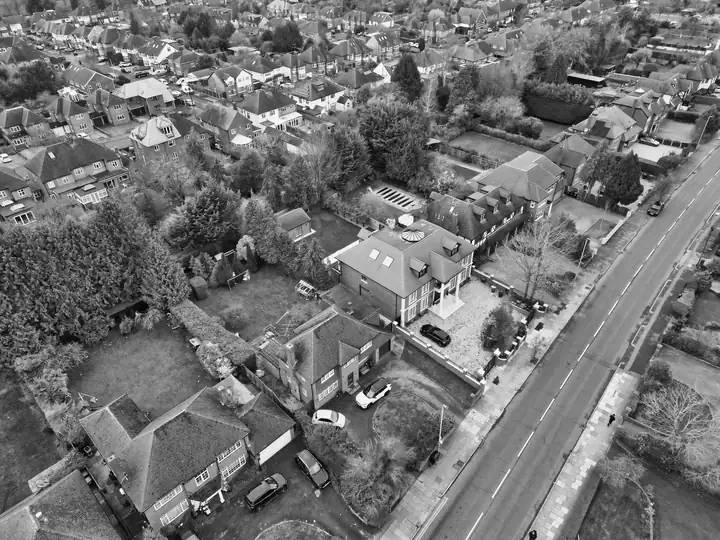Aerial view of semi-detached and detached houses with hipped and gabled roofs, the mix of rooflines that sets fascia and gutter prices in Mansfield