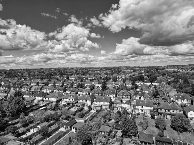 Aerial view of rows of semi-detached houses with hipped tiled roofs, the kind of estate housing around Mansfield that loses ridges and verges in storms