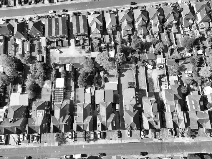 Black and white aerial view of rows of terraced houses with back additions, rear yards and long narrow gardens