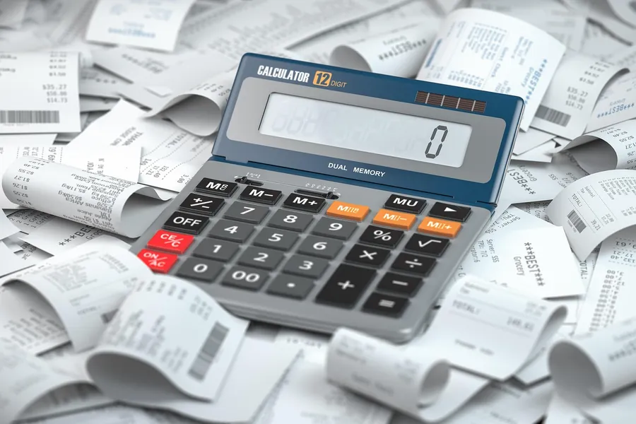 Calculator lying on a pile of printed till receipts