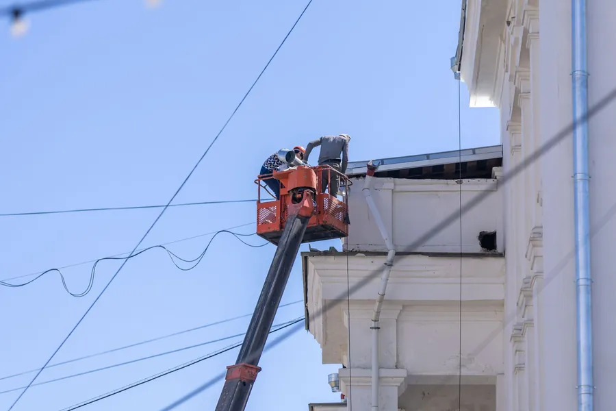 Cherry picker platform raised to the roofline of a building for work at height