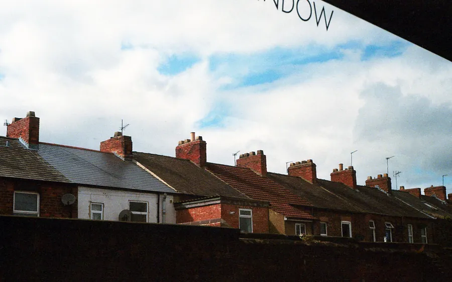A row of brick chimney stacks on older British terraced rooftops, the most common target for lead flashing theft