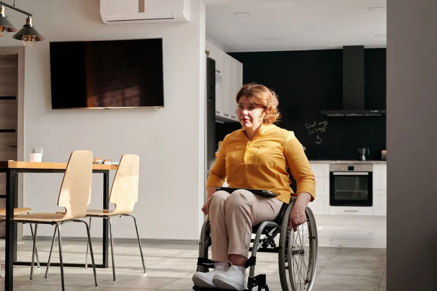 Woman using a wheelchair in an adapted kitchen, showing the kind of work a disabled facilities grant funds