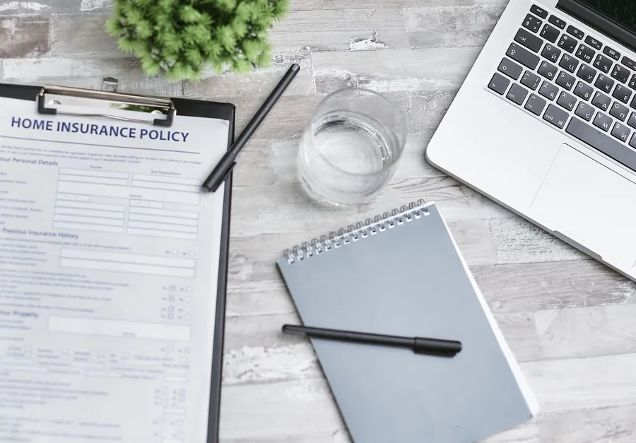 Home insurance policy documents and paperwork laid out on a desk for review
