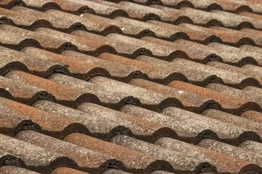 Close-up of weathered brown concrete interlocking roof tiles with faded, uneven surfaces