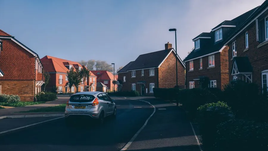 Modern new build housing estate street with concrete tiled roofs in morning light