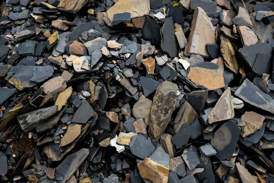 Heap of broken old roof tiles and slate rubble waiting for disposal after a roof strip