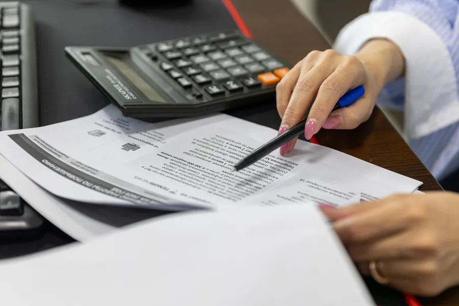 Calculator resting on an itemised quote with a pen ready to check the figures