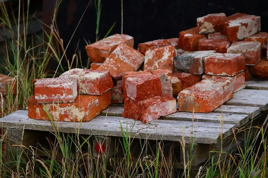 Reclaimed red bricks stacked on a pallet ready for a chimney rebuild in Mansfield