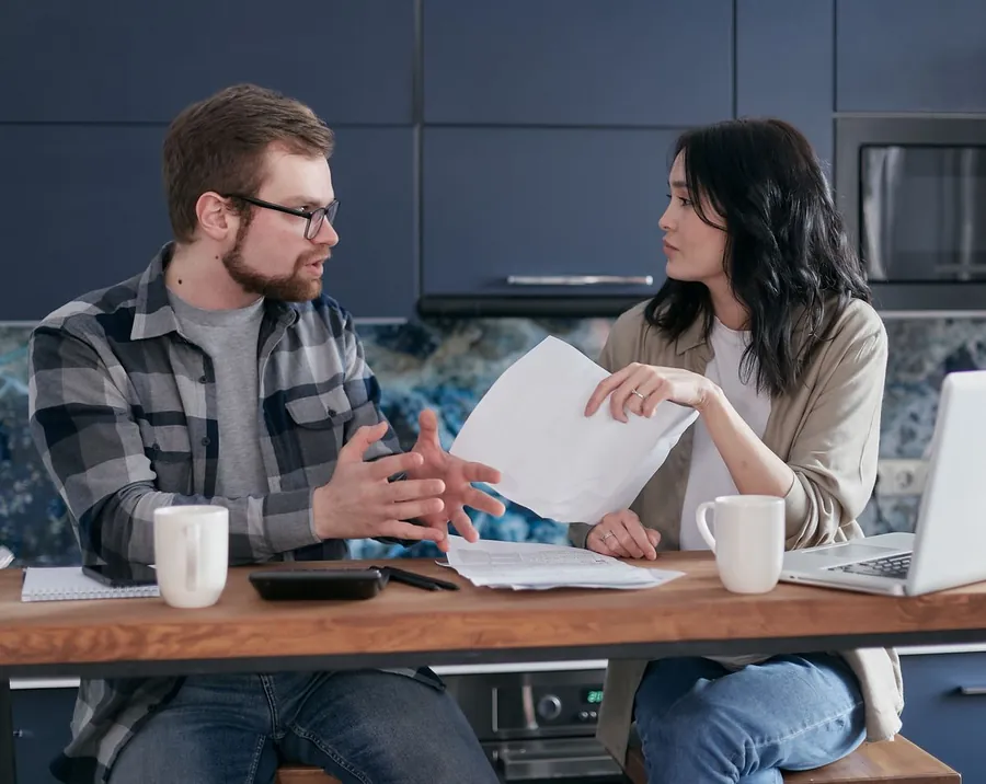 Couple at a kitchen table reviewing paperwork after a roofing guarantee claim was refused in Mansfield