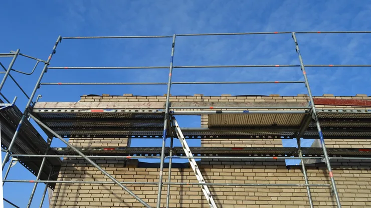 Scaffolding and a ladder run up a brick building to the roofline, the access cost that sits on top of replacing stolen lead