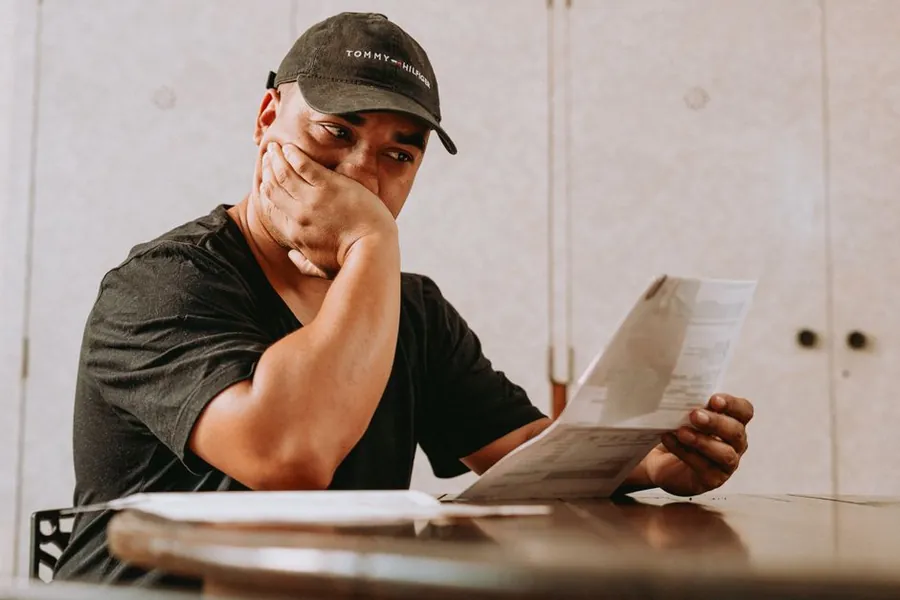 Person at a table reading paperwork about major works charges with a concerned expression