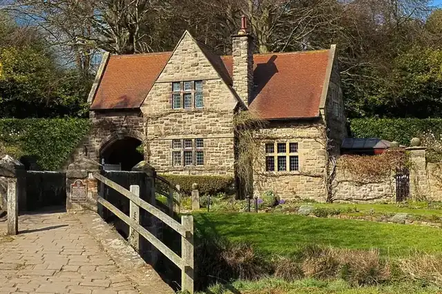 Old stone house with a clay tiled roof and brick chimneys, typical of the older buildings found in a village conservation area like Market Warsop