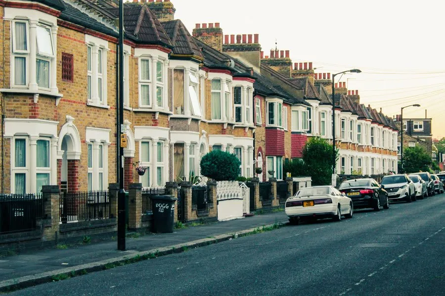 Terraced street of brick houses with parked cars after wet weather