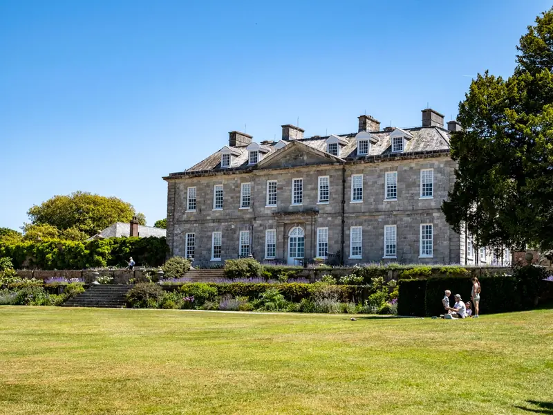 Georgian stone country house with a hipped roof set behind lawns and gardens, the style of house Berry Hill Hall represents