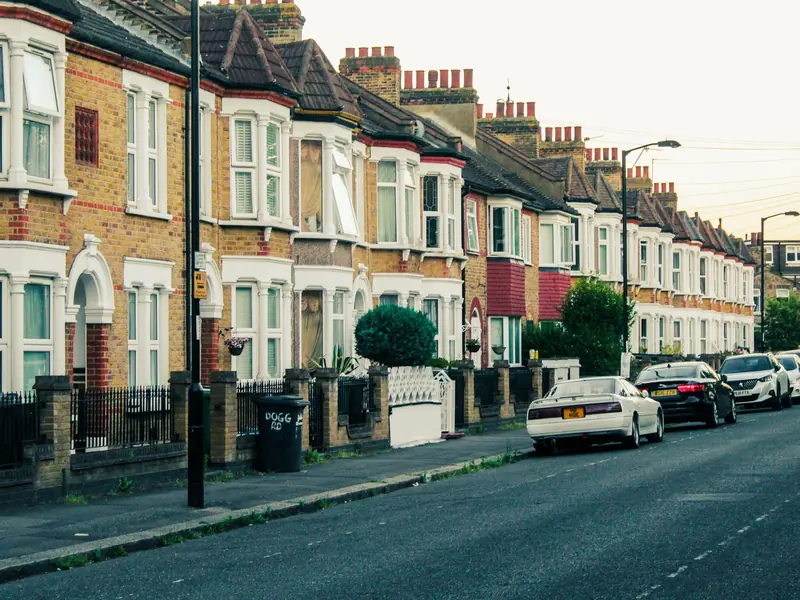 Long row of bay-fronted terraced houses with tiled roofs and chimney stacks, the kind of continuous terrace found across Forest Town