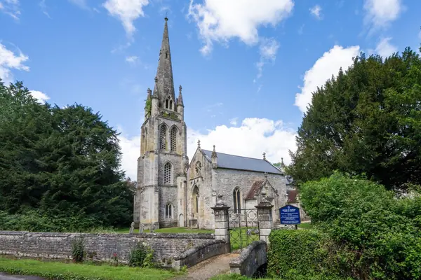 Stone parish church with a tall spire behind a churchyard wall, similar in character to St Edmund's in Mansfield Woodhouse