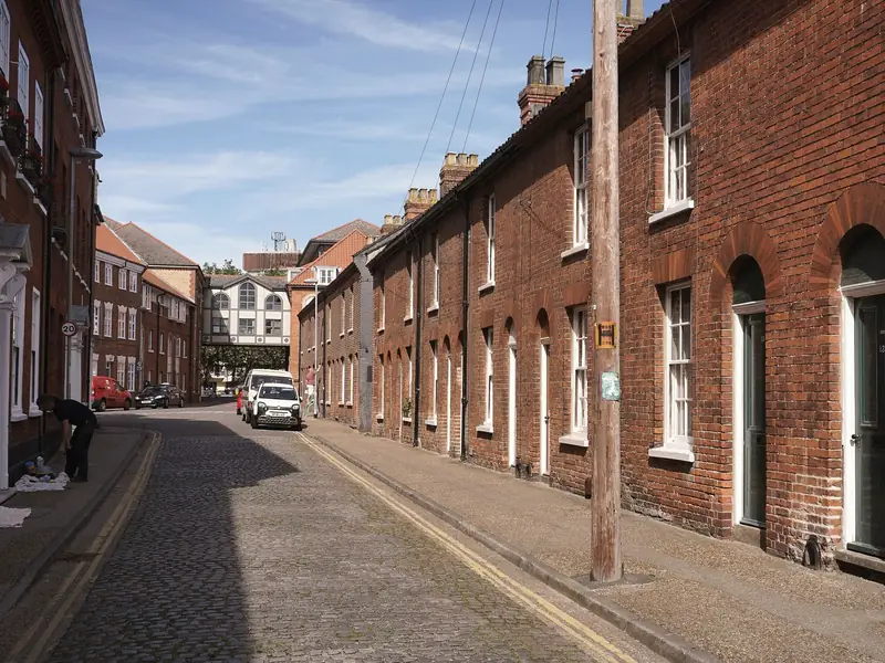 Long row of red brick terraced houses with pitched roofs and chimney stacks, similar to the colliery rows at Warsop Vale