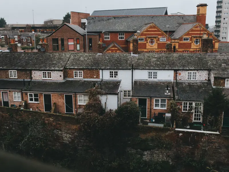 View over the backs of brick terraced houses with grey tiled roofs, rear extensions and chimney stacks