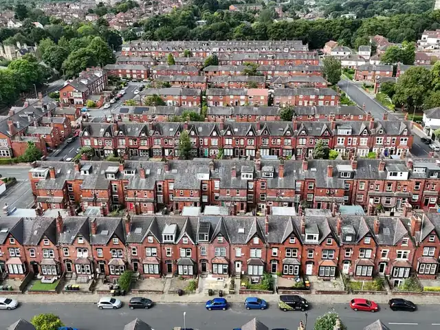 Aerial view of parallel rows of red brick terraced houses with grey roofs and chimneys, a roofscape like Shirebrook's