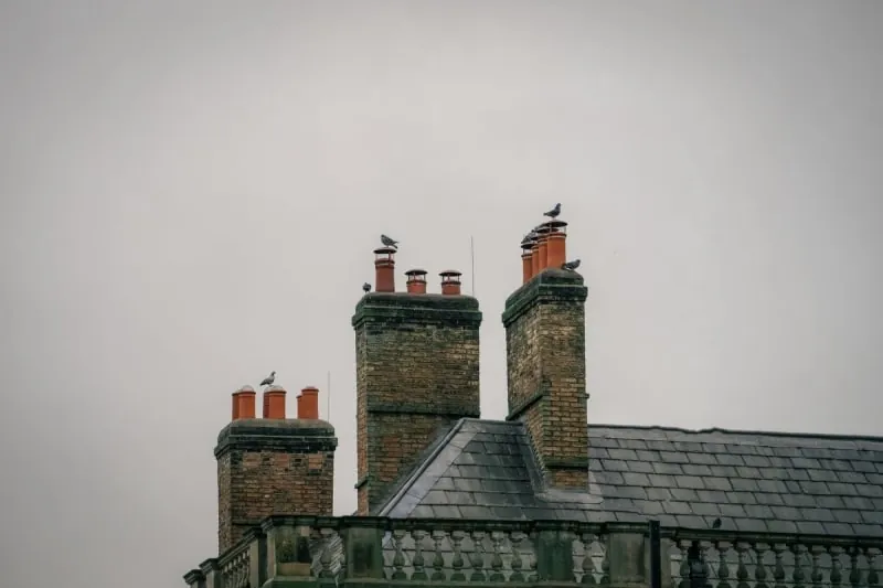 Shared brick chimney stack on a terraced roof in Mansfield awaiting repointing