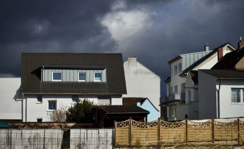 Dark storm clouds gathering over rooftops of houses in the Mansfield area